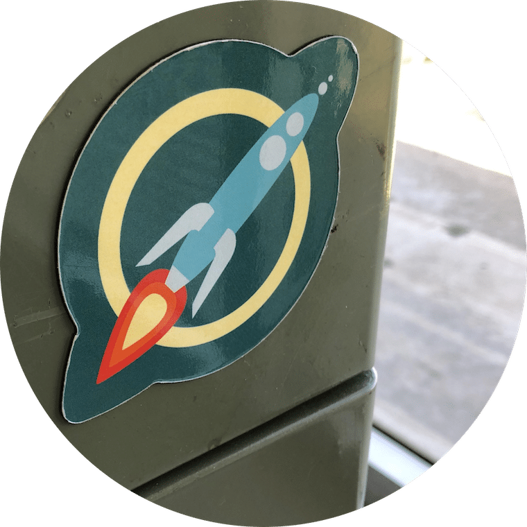 A circular magnet of the MaxFun Rocket Logo