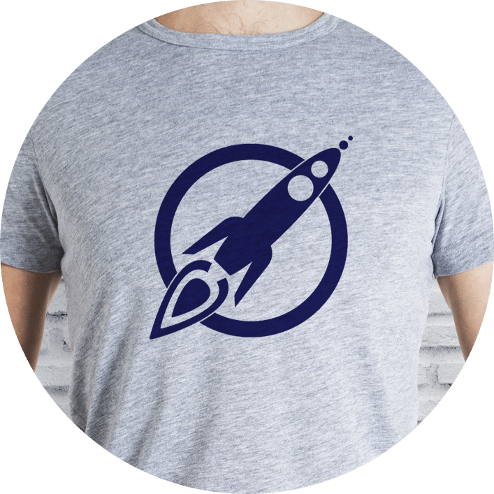 The torso of a man wearing a light heather grey t-shirt with the MaxFun Rocket Logo in navy blue on the front, covering his chest.